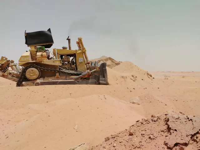 بلدوزر يسوّي الأرض في موقع إعادة تأهيل